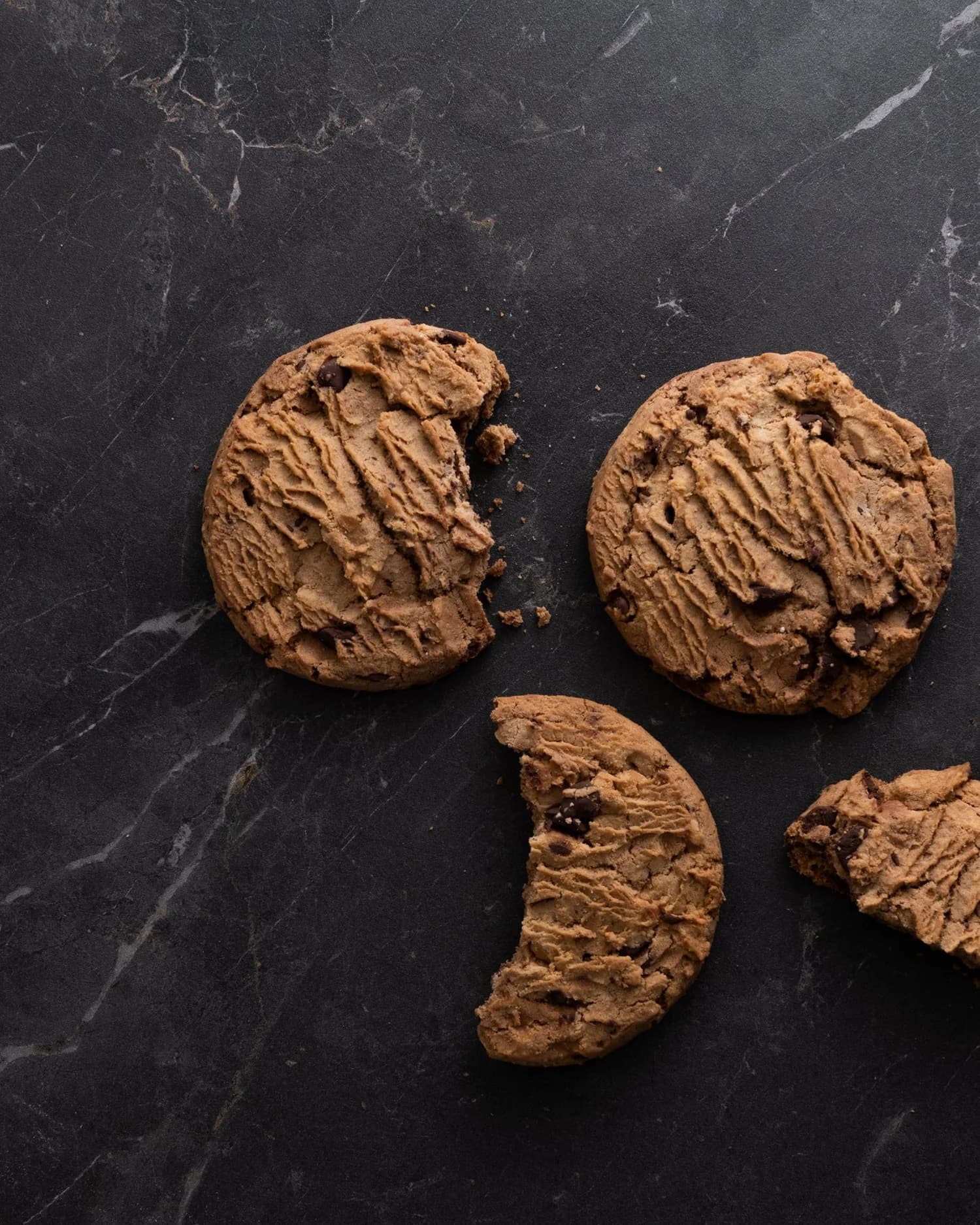 Freshly baked chocolate chip cookies on dark marble