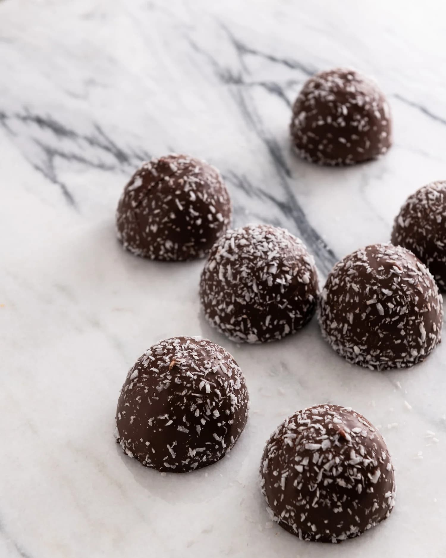 AFI chocolate snowballs rolled in coconut on white marble